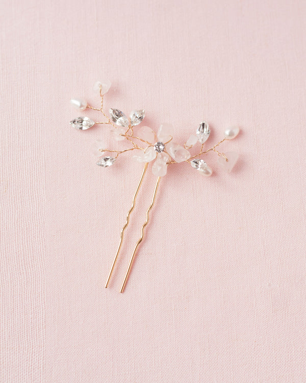 Flatlay on pink background of the Moonflower Bridal Comb in gold, with rose quartz gemstones, pearls and crystals.