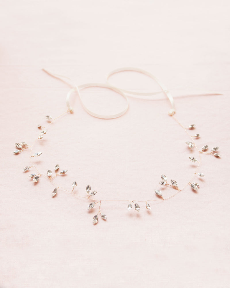 Flatlay of the Sparkling Crystal Bridal Hair Vine in gold with scattered crystals.
