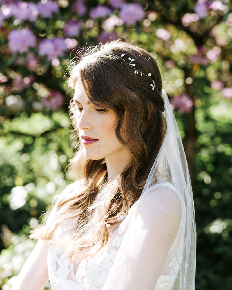 A bride wears the Sparkling crystal hair vine in gold with a simple veil.