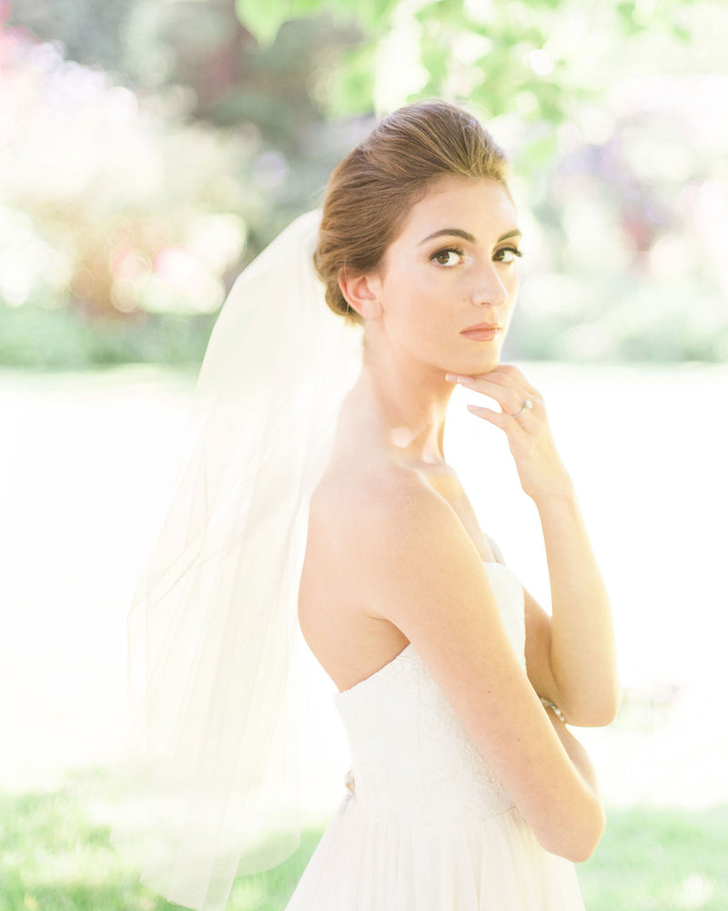 A bride wears the Symphony short two-layer waist veil.