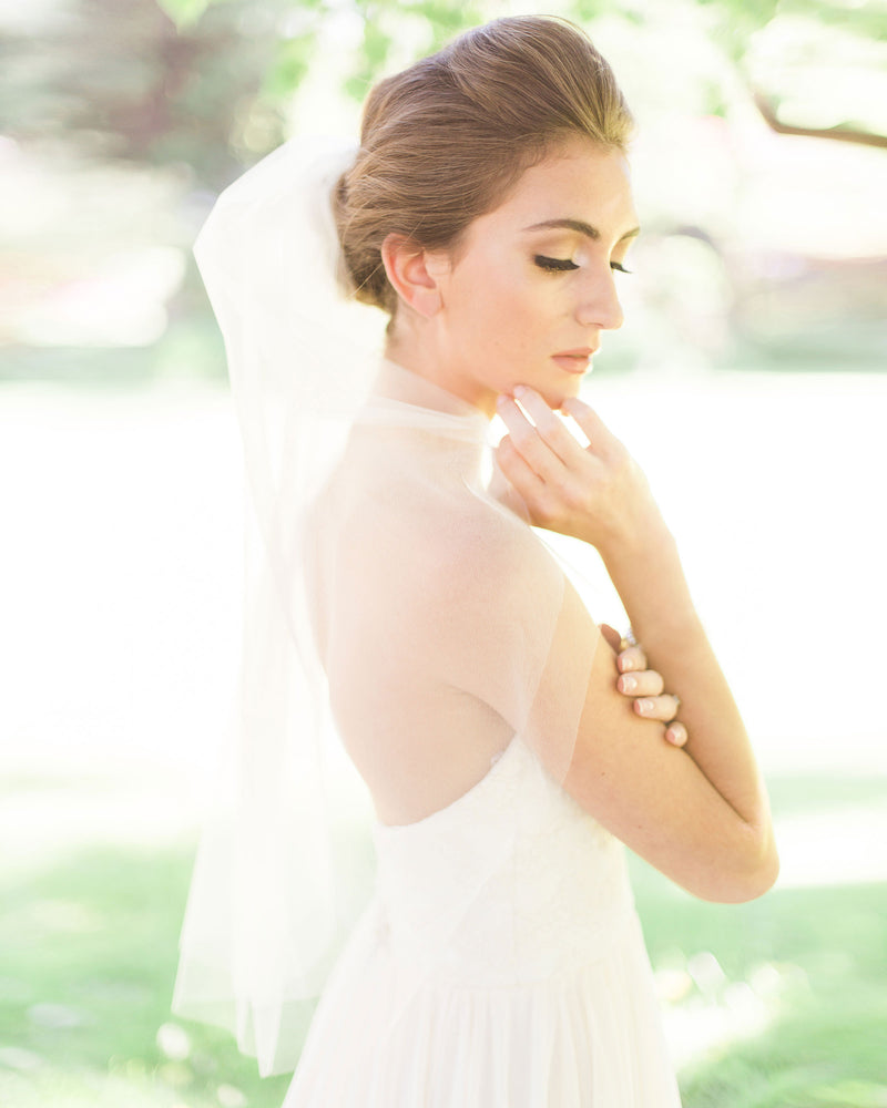 A bride wears the Symphony short two layer waist veil.