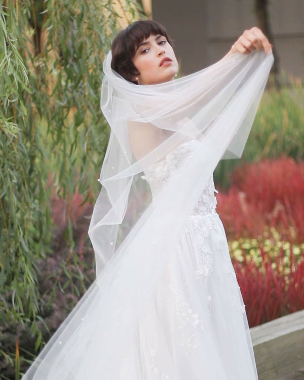 A bride models the Tansy Pearl Veil in chapel length.